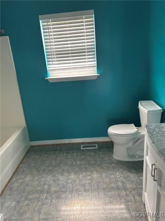 5428 Stone Ln, Henrico, VA 23227 - bathroom with vanity, toilet, a bath, baseboards, and brick patterned flooring