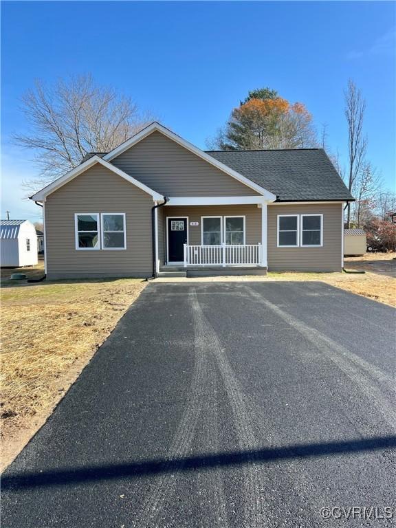 27 Otter Ln, Montross, VA 22520 - ranch-style house featuring a porch, driveway, and a storage unit