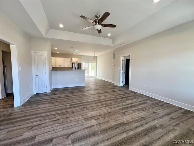 27 Otter Ln, Montross, VA 22520 - unfurnished living room featuring ceiling fan, baseboards, a raised ceiling, dark wood-style flooring, and recessed lighting