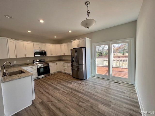 27 Otter Ln, Montross, VA 22520 - kitchen featuring appliances with stainless steel finishes, a sink, light stone counters, white cabinetry, and dark wood finished floors