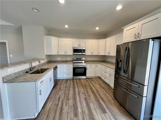 27 Otter Ln, Montross, VA 22520 - kitchen featuring appliances with stainless steel finishes, a sink, wood finished floors, white cabinets, and recessed lighting