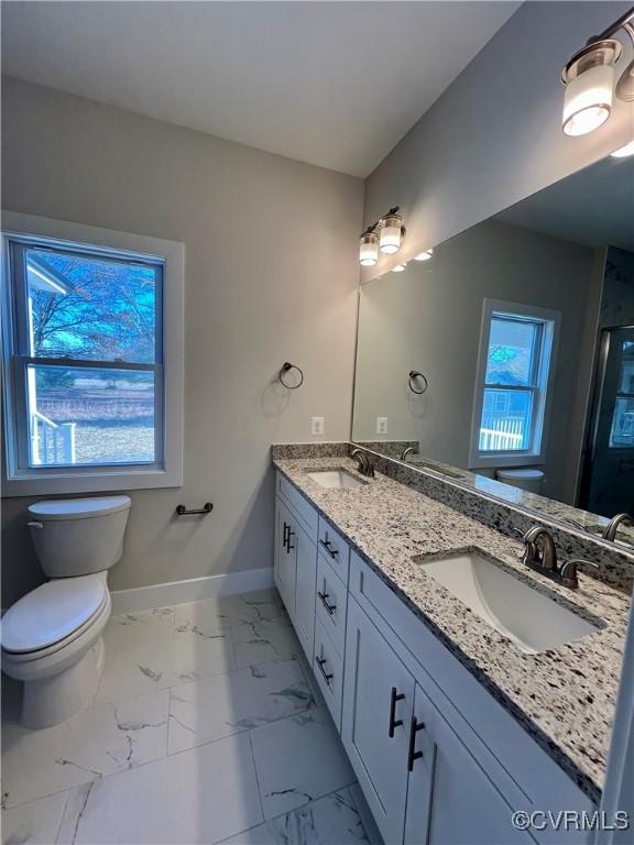 27 Otter Ln, Montross, VA 22520 - full bath featuring toilet, baseboards, double vanity, marble look tile flooring, and a shower with door