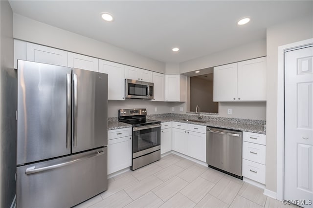 2750 Old Point Dr, Henrico, VA 23233 - kitchen featuring appliances with stainless steel finishes, a sink, white cabinets, light stone counters, and recessed lighting