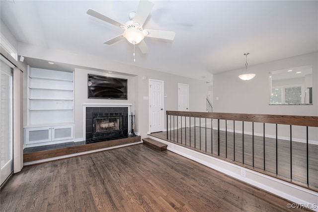 2750 Old Point Dr, Henrico, VA 23233 - unfurnished living room with wood finished floors, a tiled fireplace, a ceiling fan, and built in shelves