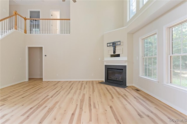 11830 Cedar Landing Ter, Chesterfield, VA 23831 - unfurnished living room with wood finished floors, healthy amount of natural light, a high ceiling, a fireplace with flush hearth, and baseboards