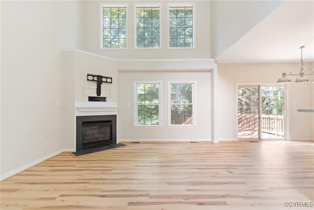 11830 Cedar Landing Ter, Chesterfield, VA 23831 - unfurnished living room with healthy amount of natural light, wood finished floors, a fireplace with flush hearth, and a towering ceiling