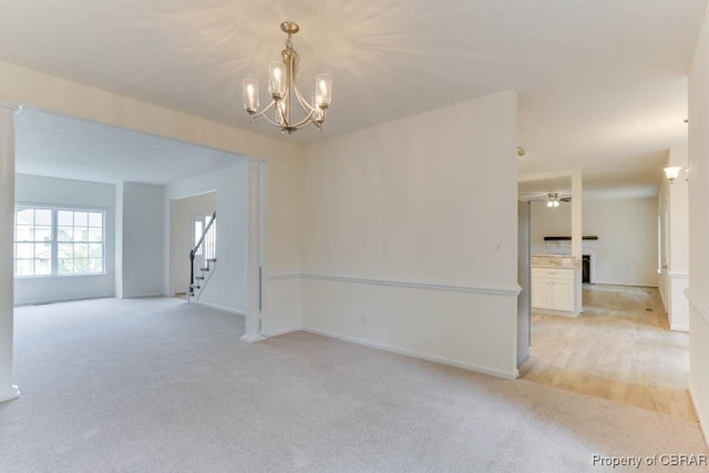 106 Haymaker Pl, Williamsburg, VA 23185 - unfurnished room with light carpet, stairs, a chandelier, a ceiling fan, and baseboards
