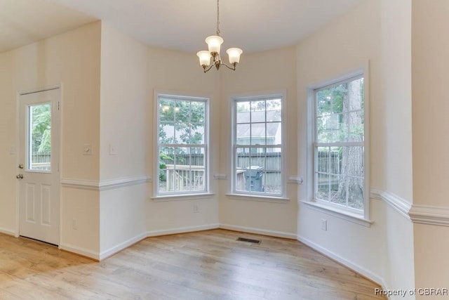 106 Haymaker Pl, Williamsburg, VA 23185 - unfurnished dining area featuring healthy amount of natural light, a chandelier, wood finished floors, and baseboards
