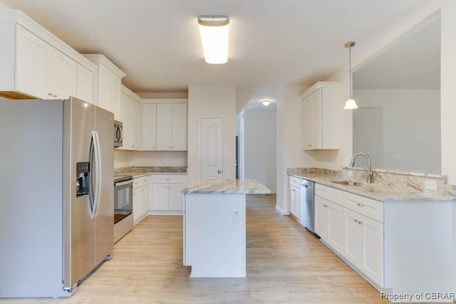 106 Haymaker Pl, Williamsburg, VA 23185 - kitchen featuring appliances with stainless steel finishes, a sink, light stone counters, light wood-style flooring, and a center island