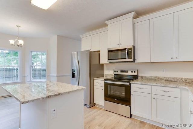 106 Haymaker Pl, Williamsburg, VA 23185 - kitchen with stainless steel appliances, light wood finished floors, a kitchen island, white cabinetry, and a chandelier