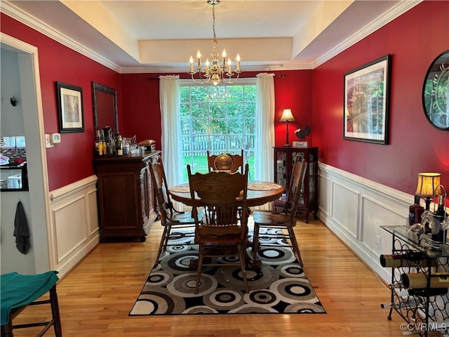 15023 Manor Gate Ct, Midlothian, VA 23112 - dining area featuring a raised ceiling, light wood-style floors, a chandelier, a decorative wall, and a wainscoted wall