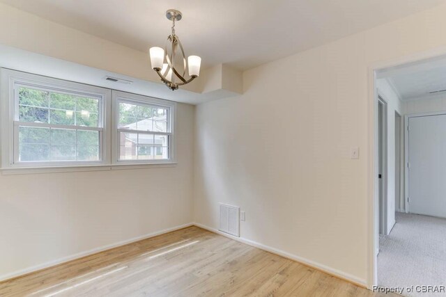 205 Captains Ct, Hampton, VA 23669 - unfurnished room with a chandelier, light wood finished floors, and baseboards