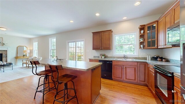 11706 Black Alder Dr, Moseley, VA 23120 - kitchen featuring black appliances, plenty of natural light, light wood-style floors, a breakfast bar, and recessed lighting