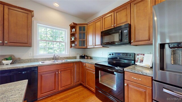 11706 Black Alder Dr, Moseley, VA 23120 - kitchen with black appliances, a sink, brown cabinets, light wood-style floors, and glass insert cabinets