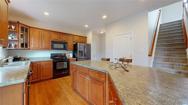 11706 Black Alder Dr, Moseley, VA 23120 - kitchen featuring black appliances, a sink, brown cabinetry, recessed lighting, and light wood-style floors