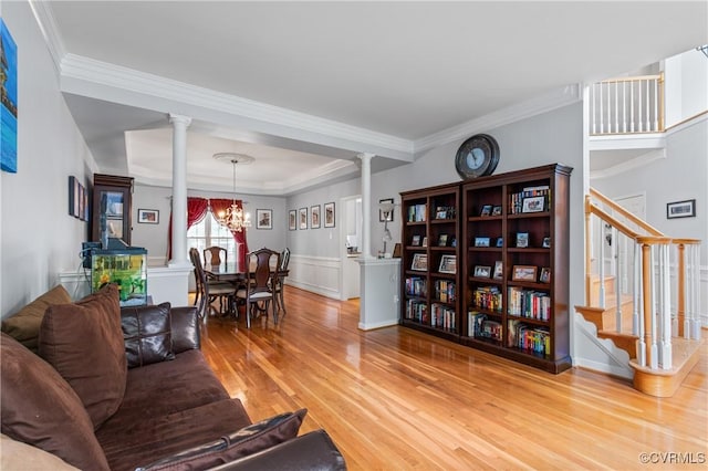 8940 Kings Charter Dr, Hanover, VA 23116 - living area featuring decorative columns, ornamental molding, wood finished floors, stairs, and a chandelier