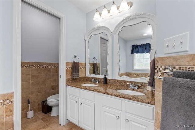 8940 Kings Charter Dr, Hanover, VA 23116 - bathroom featuring tile walls, double vanity, tile patterned floors, and wainscoting