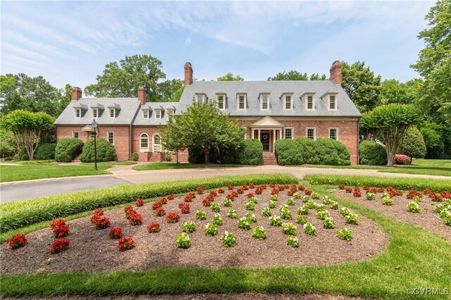 8940 Kings Charter Dr, Hanover, VA 23116 - cape cod house with brick siding, a chimney, and a front lawn