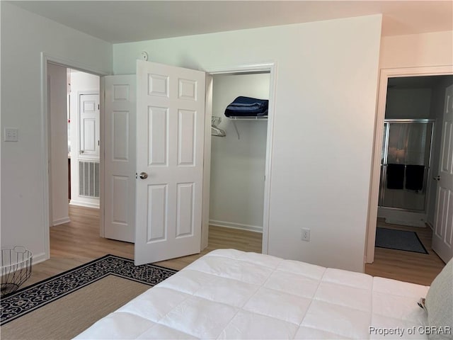 230 Roseneath Ave, Kilmarnock, VA 22482 - bedroom featuring wood finished floors, a closet, baseboards, connected bathroom, and a spacious closet