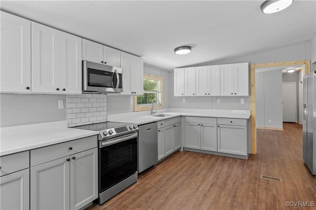 10780 Winchester Dr, Amelia Courthouse, VA 23002 - kitchen with stainless steel appliances, wood finished floors, light countertops, and white cabinetry
