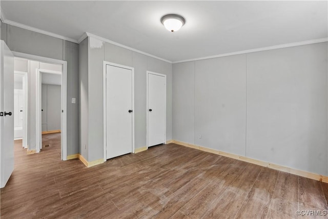 10780 Winchester Dr, Amelia Courthouse, VA 23002 - unfurnished bedroom featuring ornamental molding, wood finished floors, and two closets