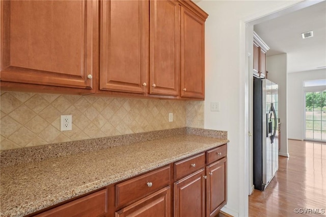 8156 Cool Summer Dr, Mechanicsville, VA 23111 - kitchen featuring stainless steel fridge, backsplash, light stone counters, and brown cabinetry