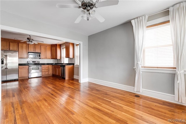 613 Roseneath Rd Unit U1, Richmond, VA 23221 - kitchen with stainless steel appliances, dark countertops, ceiling fan, brown cabinets, and baseboards