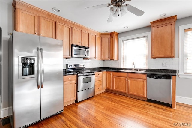 613 Roseneath Rd Unit U1, Richmond, VA 23221 - kitchen with stainless steel appliances, dark countertops, a sink, light wood-type flooring, and plenty of natural light