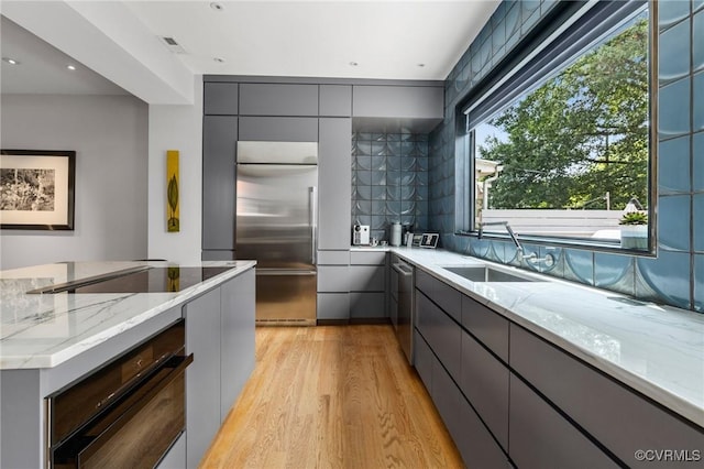 114 S Colonial Ave, Richmond, VA 23221 - kitchen featuring appliances with stainless steel finishes, gray cabinetry, light wood-type flooring, and modern cabinets