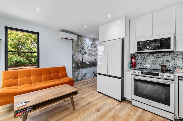 114 S Colonial Ave, Richmond, VA 23221 - kitchen featuring white appliances, a wall mounted AC, white cabinets, light wood finished floors, and tasteful backsplash