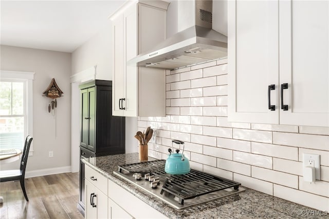 12025 Autumn Knoll Dr, Mechanicsville, VA 23116 - kitchen with wall chimney exhaust hood, stainless steel gas stovetop, light stone counters, white cabinets, and light wood finished floors