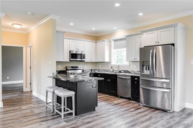 8315 Namozine Rd, Amelia Courthouse, VA 23002 - kitchen with appliances with stainless steel finishes, a peninsula, crown molding, light wood-style flooring, and a breakfast bar