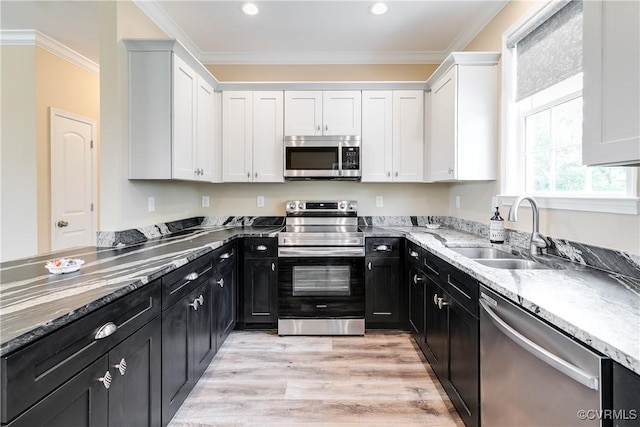 8315 Namozine Rd, Amelia Courthouse, VA 23002 - kitchen featuring appliances with stainless steel finishes, dark cabinetry, white cabinetry, a sink, and light stone countertops