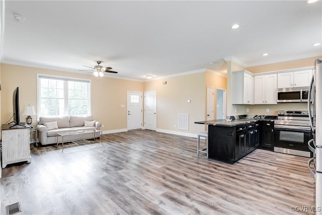 8315 Namozine Rd, Amelia Courthouse, VA 23002 - kitchen featuring appliances with stainless steel finishes, dark cabinets, white cabinetry, healthy amount of natural light, and crown molding