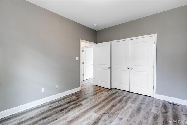 8315 Namozine Rd, Amelia Courthouse, VA 23002 - unfurnished bedroom featuring wood finished floors, baseboards, and a closet