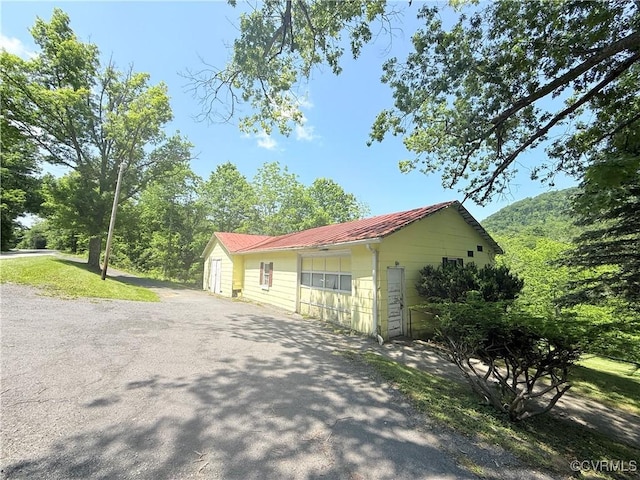 12509 Sam Snead Hwy, Warm Springs, VA 24484 - view of side of property featuring metal roof, asphalt driveway, and a detached garage