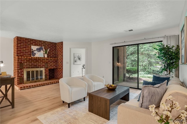 2106 Turtle Run Dr Unit 3, Henrico, VA 23233 - living area featuring light wood-style floors, a textured ceiling, and a fireplace