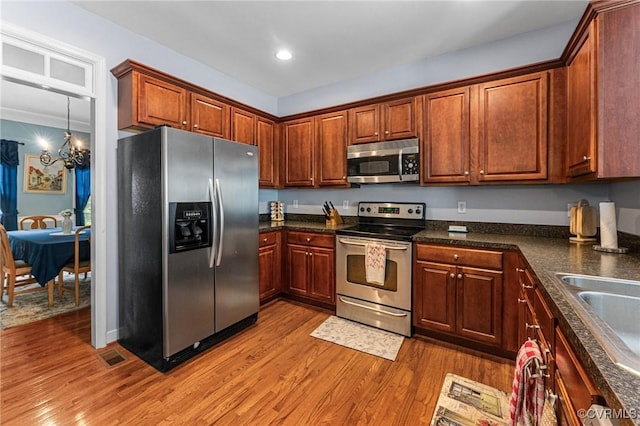 3321 Ceres Rd, Henrico, VA 23294 - kitchen with stainless steel appliances, wood finished floors, dark countertops, a chandelier, and recessed lighting