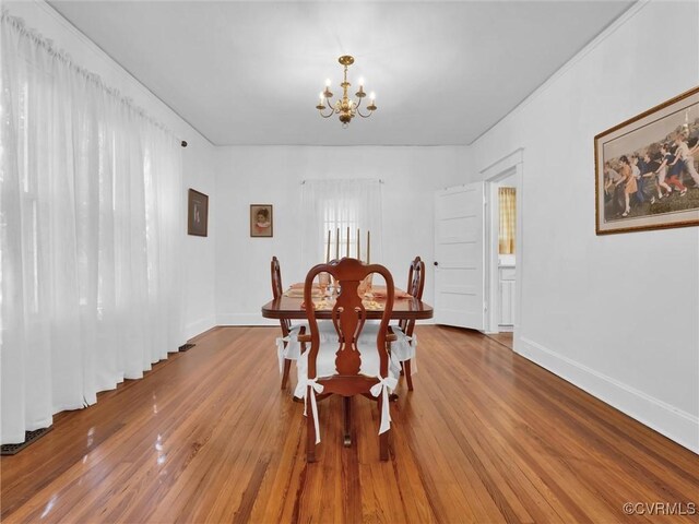 110 Gatewood Ave, Crewe, VA 23930 - dining room featuring a chandelier, wood finished floors, and baseboards