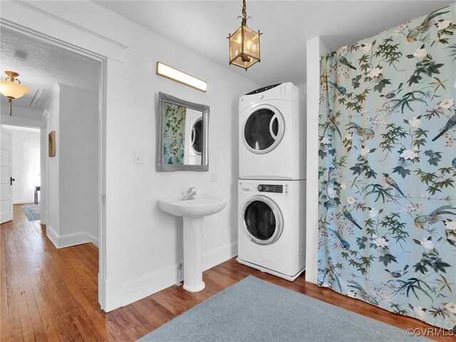 110 Gatewood Ave, Crewe, VA 23930 - laundry room featuring stacked washer / drying machine, wood finished floors, baseboards, and a chandelier
