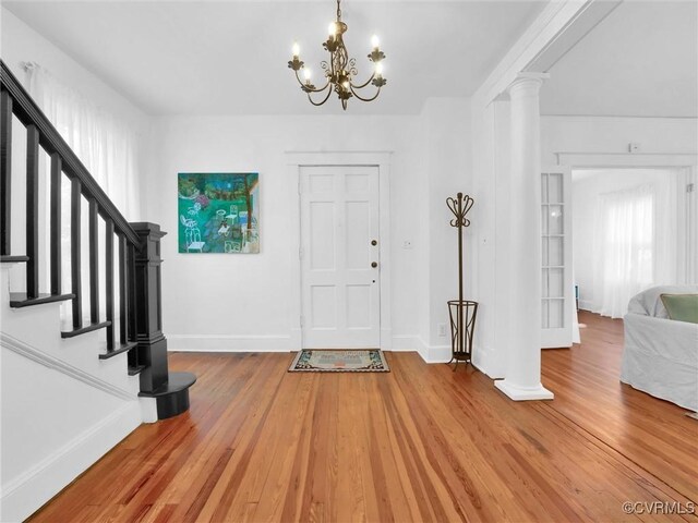110 Gatewood Ave, Crewe, VA 23930 - foyer with wood finished floors, baseboards, a chandelier, stairway, and ornate columns