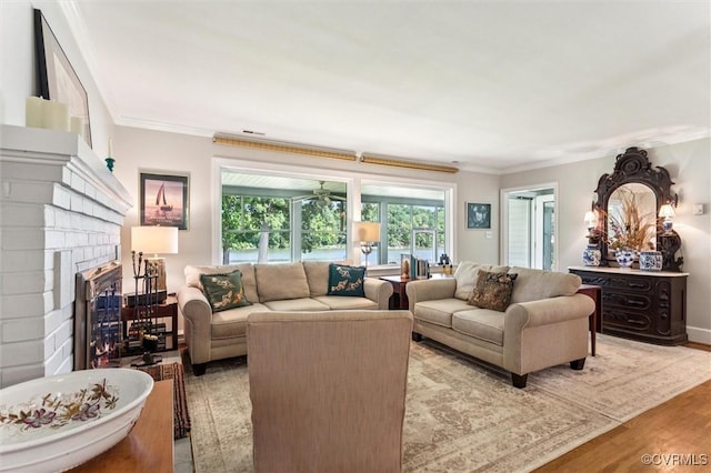 183 Nimcock Rd, Urbanna, VA 23175 - living room featuring crown molding, wood finished floors, and a brick fireplace