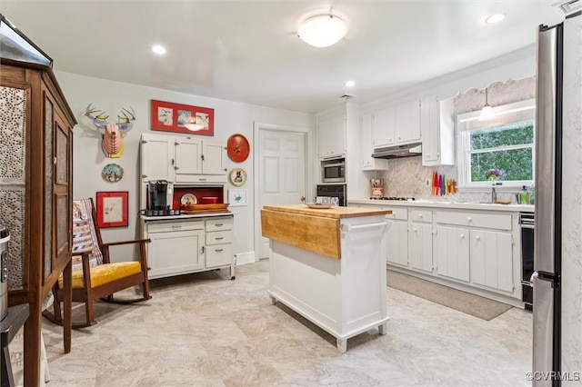 183 Nimcock Rd, Urbanna, VA 23175 - kitchen with stainless steel appliances, under cabinet range hood, white cabinets, backsplash, and recessed lighting