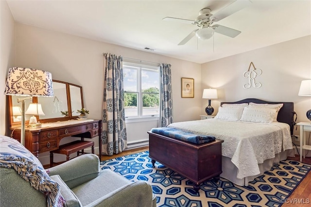 183 Nimcock Rd, Urbanna, VA 23175 - bedroom featuring wood finished floors, baseboard heating, and a ceiling fan