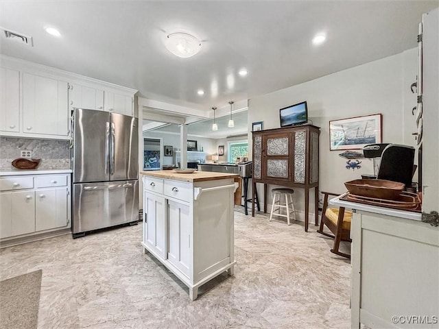 183 Nimcock Rd, Urbanna, VA 23175 - kitchen with freestanding refrigerator, white cabinetry, decorative backsplash, hanging light fixtures, and recessed lighting