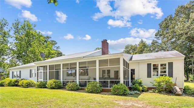 183 Nimcock Rd, Urbanna, VA 23175 - rear view of house featuring a chimney, a lawn, and a sunroom