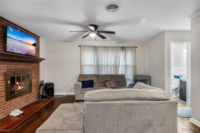 1939 Burks St, Petersburg, VA 23805 - living room featuring wood finished floors, a brick fireplace, a ceiling fan, and baseboards