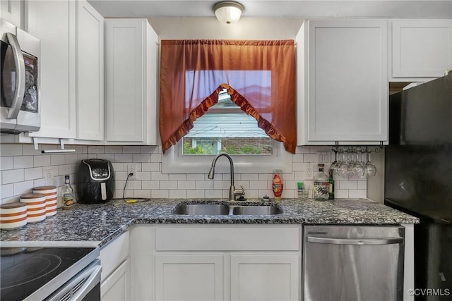 1939 Burks St, Petersburg, VA 23805 - kitchen with appliances with stainless steel finishes, a sink, white cabinetry, and tasteful backsplash