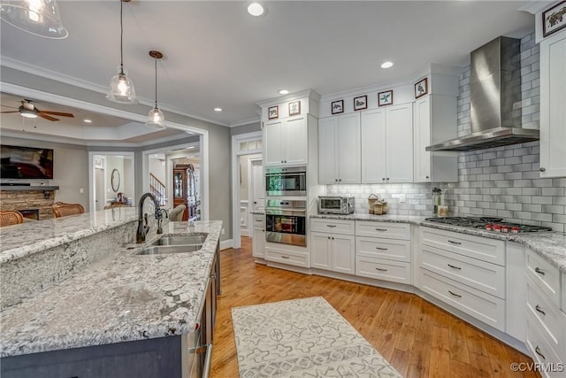 12700 Dell Hill Ct, Chester, VA 23831 - kitchen featuring wall chimney exhaust hood, a sink, stainless steel appliances, crown molding, and white cabinetry