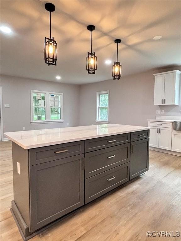 7906 Battlefield Park Rd, Henrico, VA 23231 - kitchen featuring white cabinetry, light wood-style flooring, a kitchen island, and pendant lighting